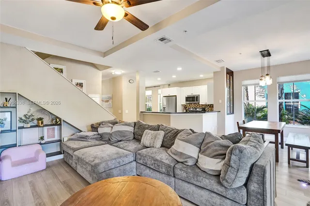 a living room with furniture a chandelier and a large window