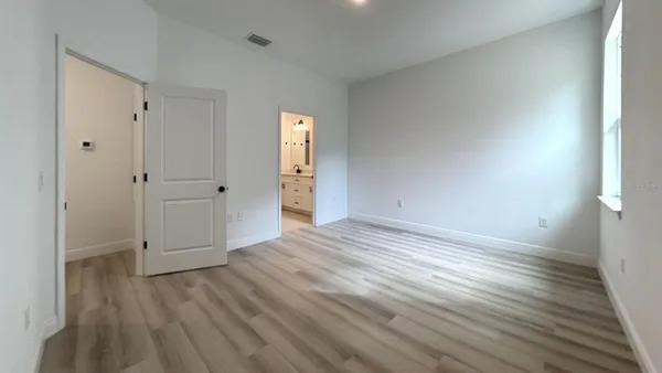 a view of empty room with wooden floor