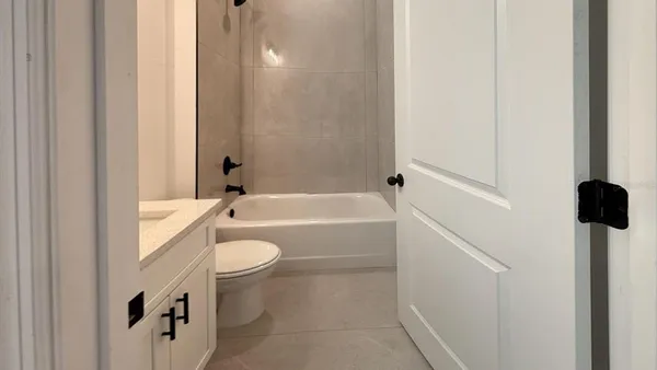 a bathroom with a granite countertop toilet a sink and bathtub