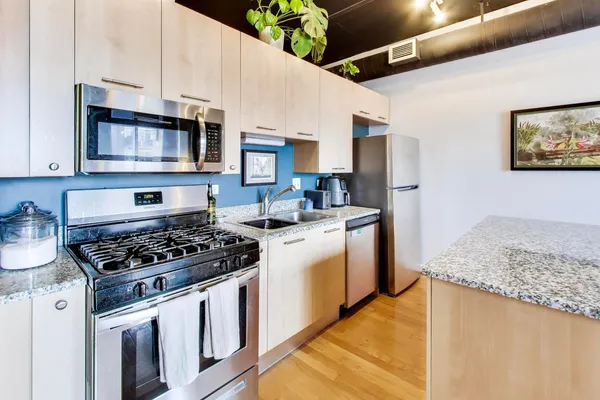 a kitchen with stainless steel appliances granite countertop a stove and a sink
