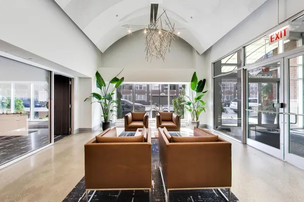 a living room with furniture floor to ceiling window and wooden floor