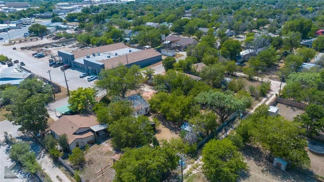 an aerial view of residential house with outdoor space and trees all around