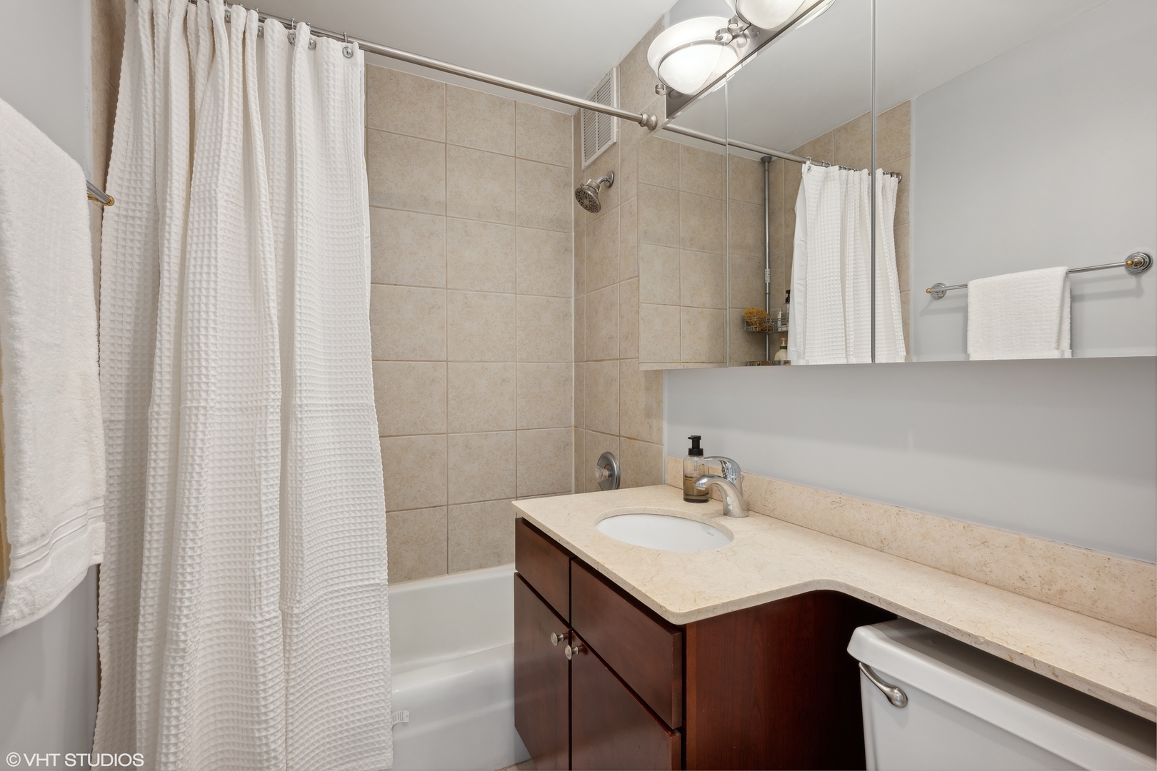 655 West Irving Park Road, Unit 5413 Chicago, IL 60613 - Photo 13 of 23 a bathroom with a sink and a mirror