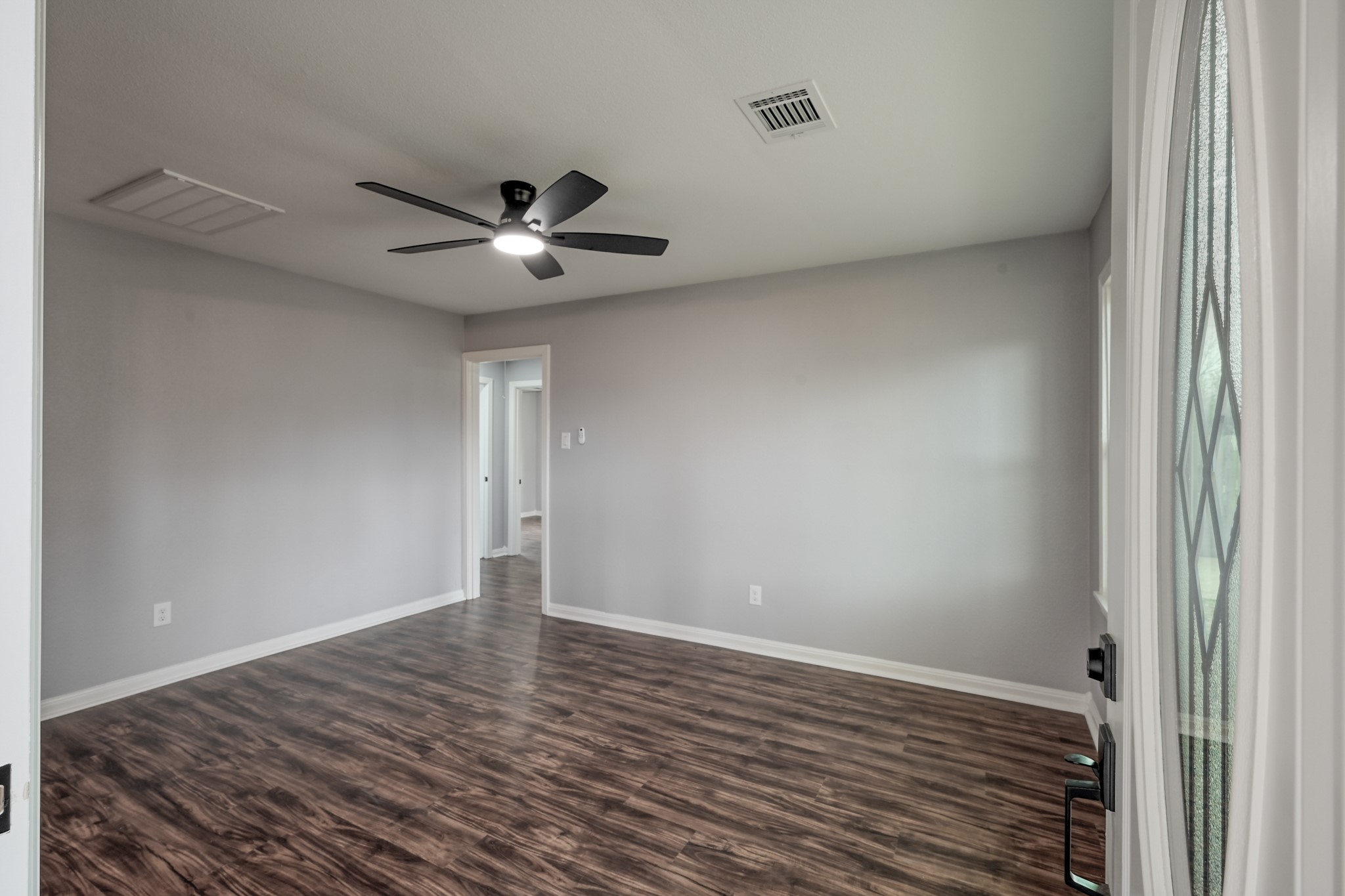 513 Barkley Street Houston, TX 77022 - Photo 6 of 48 This Formal Living room features modern wood flooring, neutral gray walls, and a ceiling fan with lighting. It has a bright and open feel, with a doorway leading to another room.