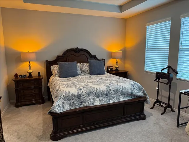 a bed sitting in a bedroom next to a lamp