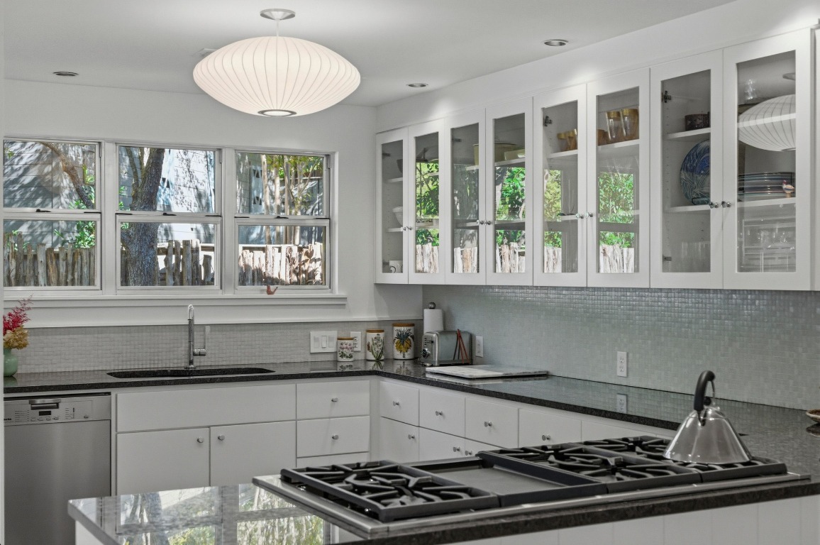 1712 West 10th Street Austin, TX 78703 - Photo 10 of 34 a kitchen with stainless steel appliances a stove a sink and a large window