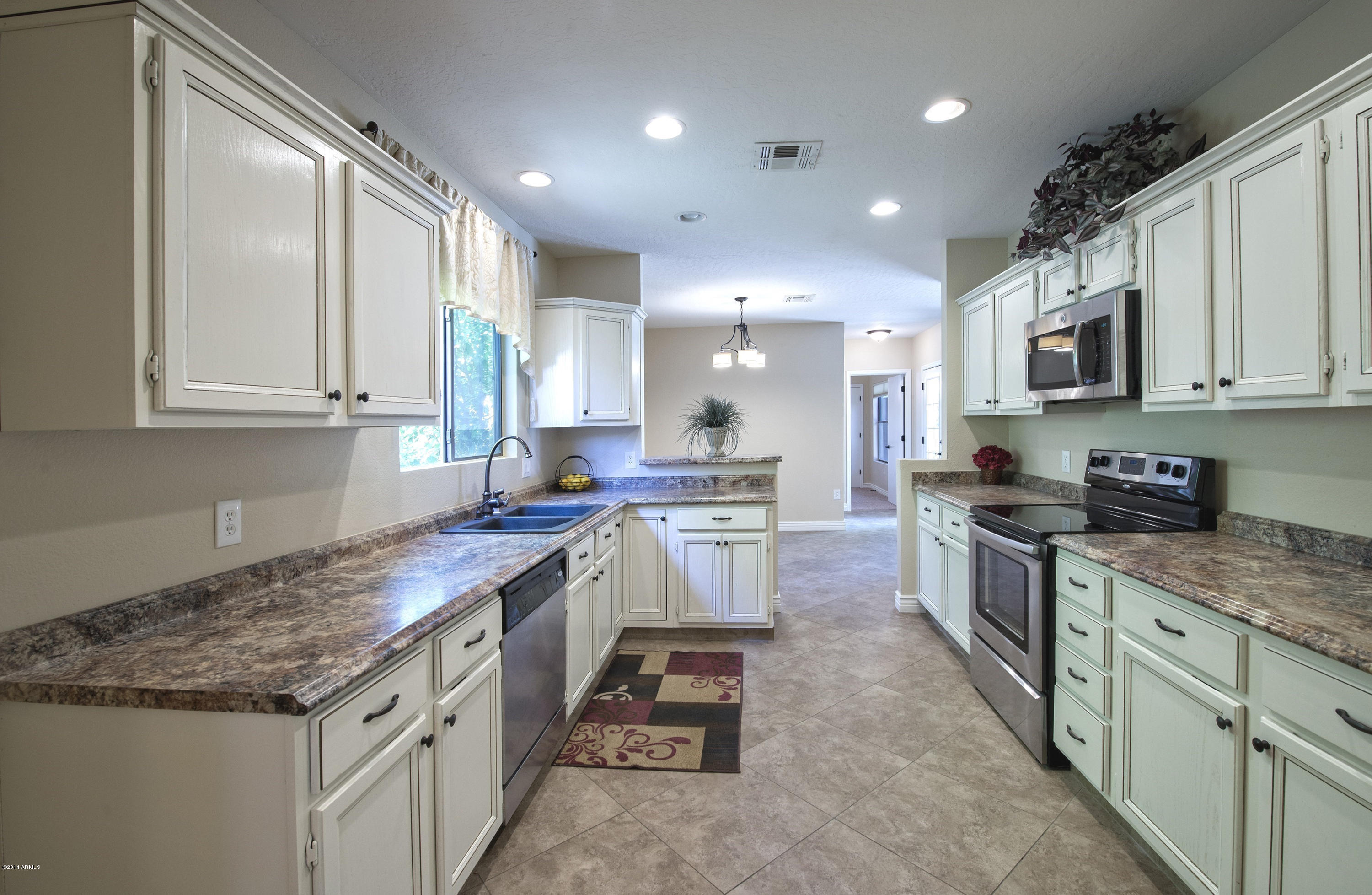 1268 East Mineral Road Gilbert, AZ 85234 - Photo 4 of 18 a kitchen with kitchen island granite countertop a stove sink and cabinets