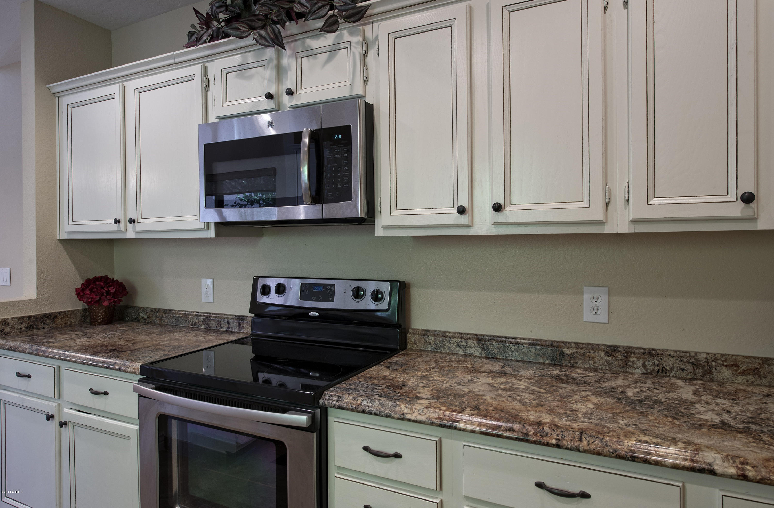 1268 East Mineral Road Gilbert, AZ 85234 - Photo 5 of 18 a kitchen with stainless steel appliances granite countertop white cabinets and a stove top oven