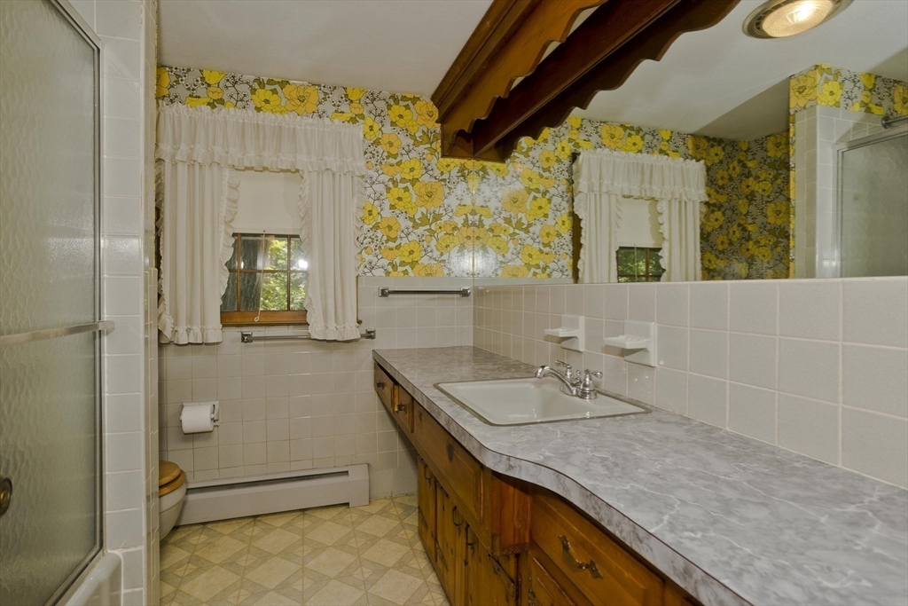 102 West Meadowview Road Holyoke, MA 01040 - Photo 19 of 39 a bathroom with a granite countertop sink a mirror and a shower