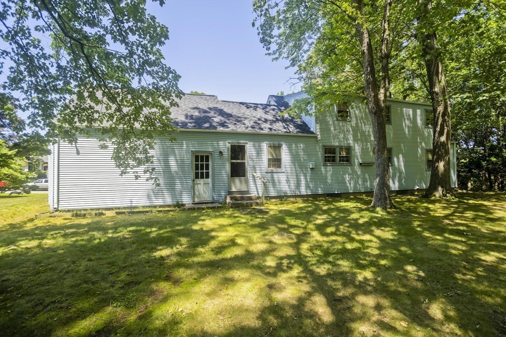 102 West Meadowview Road Holyoke, MA 01040 - Photo 35 of 39 a backyard of a house with table and chairs under an umbrella