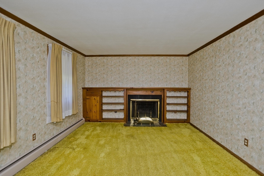 102 West Meadowview Road Holyoke, MA 01040 - Photo 6 of 39 a view of an empty room with a fireplace and a window