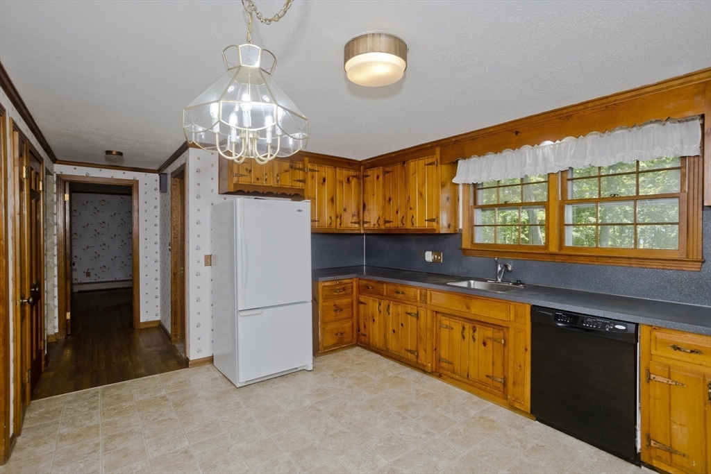 102 West Meadowview Road Holyoke, MA 01040 - Photo 10 of 39 a kitchen with stainless steel appliances granite countertop a refrigerator a sink dishwasher a stove and a dining table with wooden floor