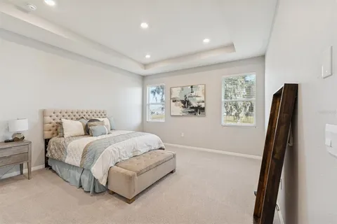 a spacious bedroom with a bed and a flat screen tv