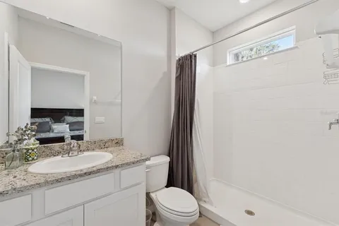 a bathroom with a granite countertop sink toilet and shower