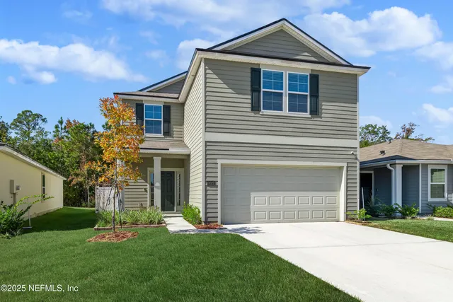 a front view of a house with a yard and garage