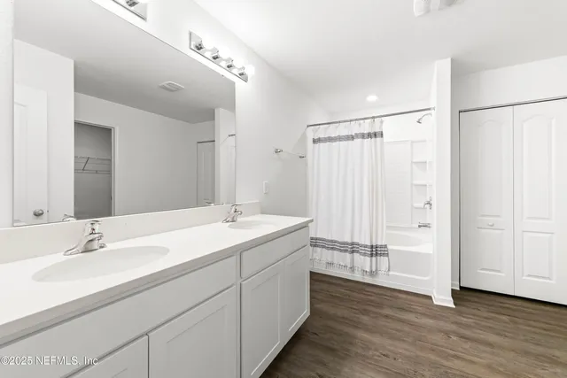 a bathroom with a double vanity sink and mirror
