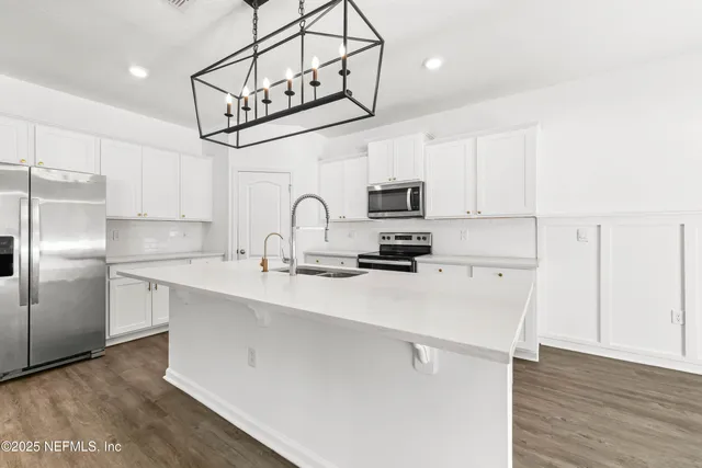 a kitchen with kitchen island a sink stainless steel appliances and cabinets