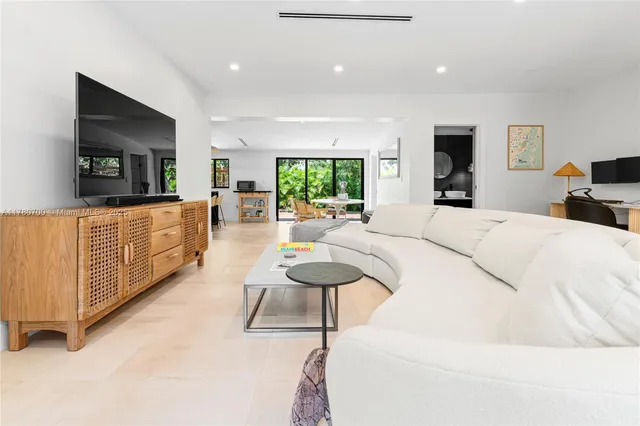 a large bedroom with a bed and a flat tv screen on dresser