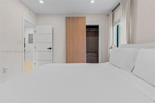 a large white bed in a white room