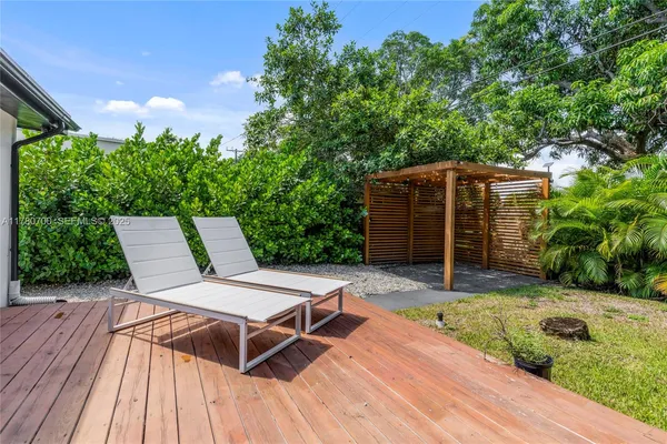 a backyard of a house with barbeque oven table and chairs
