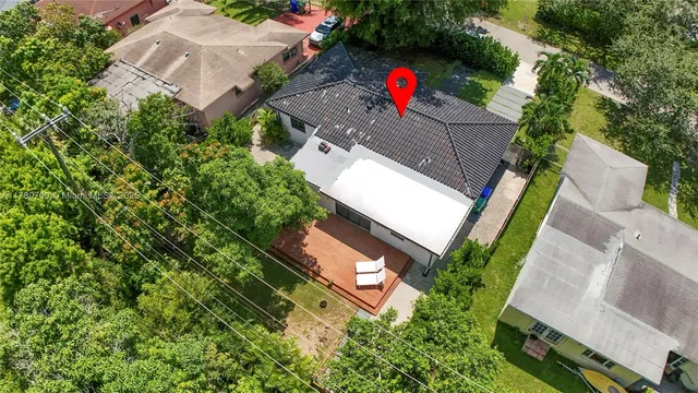 an aerial view of residential houses with outdoor space and trees