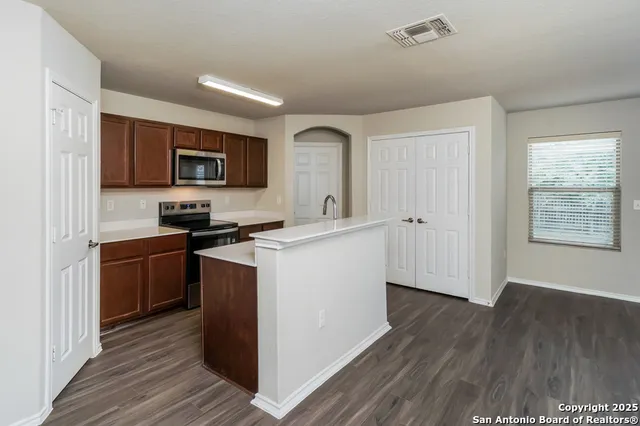 a kitchen with stainless steel appliances granite countertop a stove a sink and a refrigerator