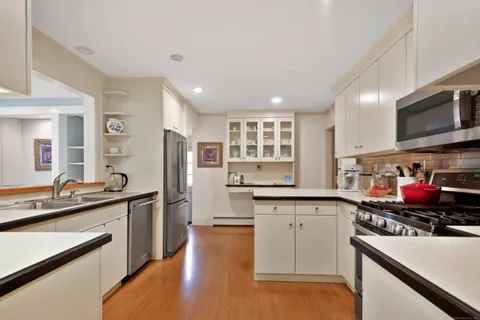 a kitchen with stainless steel appliances granite countertop a sink stove and cabinets