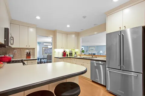 a kitchen with kitchen island a sink appliances and cabinets