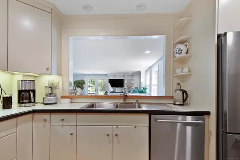 a kitchen with stainless steel appliances granite countertop a sink and a refrigerator