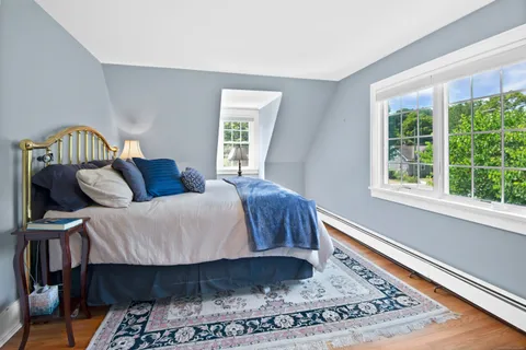 a bedroom with a bed a window and potted plant