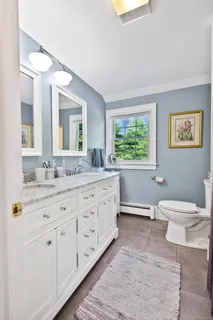 a bathroom with a granite countertop toilet sink and mirror