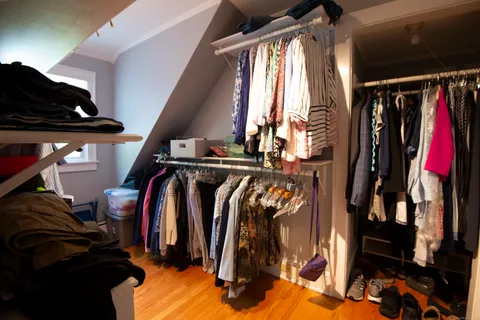 a view of walk in closet with clothes and shoes