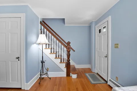 a view of a hallway with wooden floor and staircase