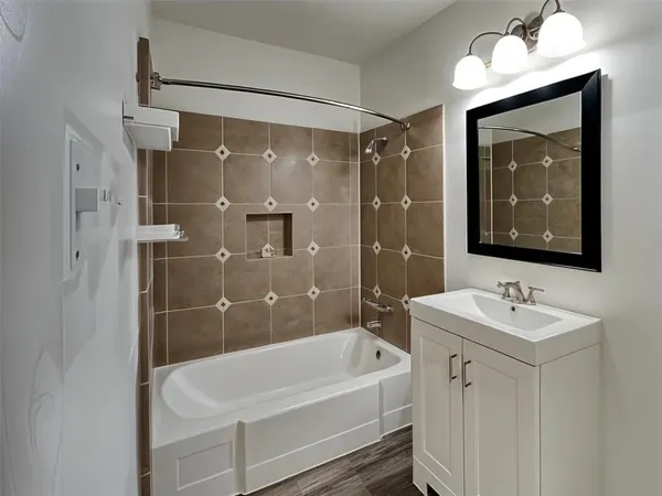 a bathroom with a bathtub a shower a sink and mirror