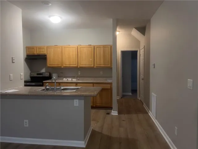 a kitchen with kitchen island granite countertop a sink stove and cabinets