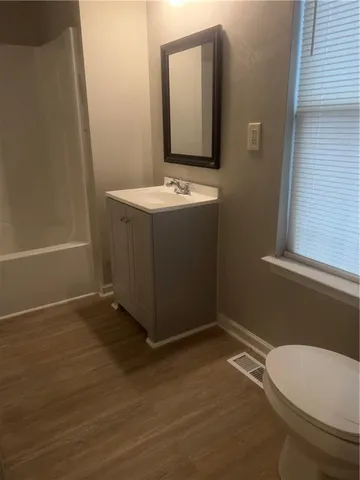 a bathroom with a sink a toilet and a mirror