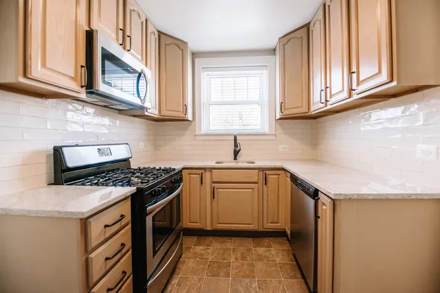a kitchen with stainless steel appliances granite countertop a stove and a sink