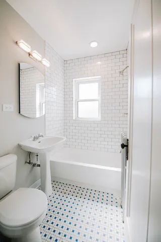 a bathroom with a bathtub a toilet a sink and a shower