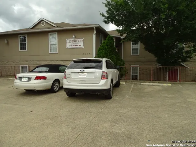 a white car parked in front of a house