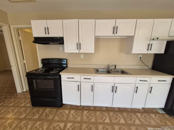 a kitchen with stainless steel appliances granite countertop a refrigerator sink and white cabinets