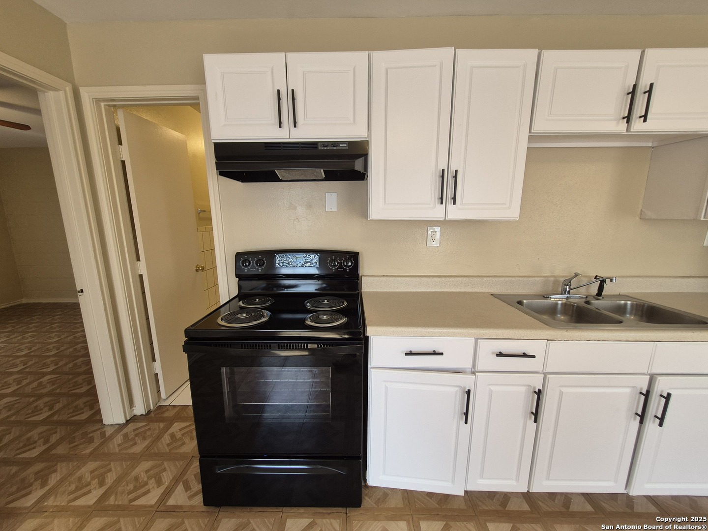 1016 Blanco Road, Unit 203 San Antonio, TX 78212 - Photo 6 of 12 a kitchen with granite countertop white cabinets and black appliances