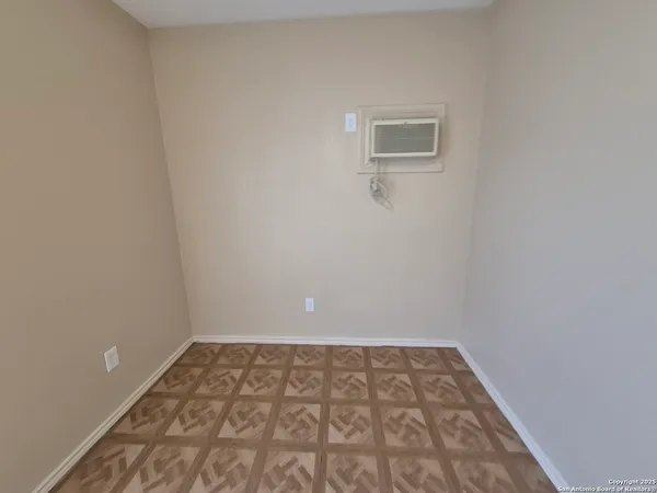 a view of a room with wooden floor and a window