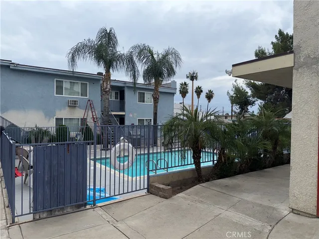 a view of a house with a small yard and palm trees