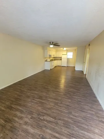 an empty room with windows and fan