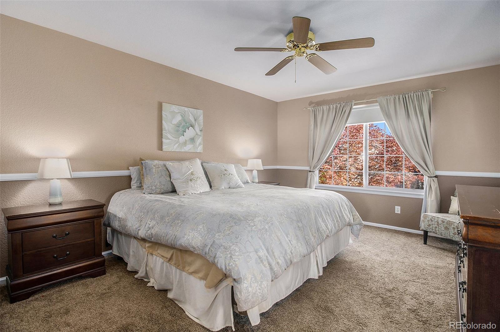1082 Riddlewood Road Highlands Ranch, CO 80129 - Photo 15 of 28 a bedroom with a bed and a chandelier