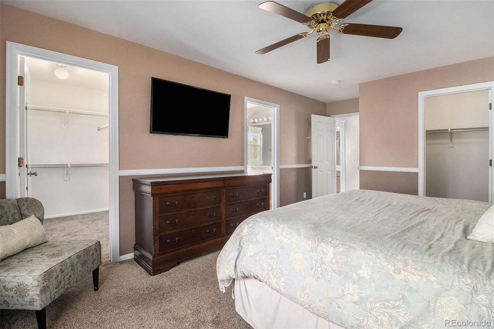 1082 Riddlewood Road Highlands Ranch, CO 80129 - Photo 16 of 28 a spacious bedroom with a bed and a flat screen tv