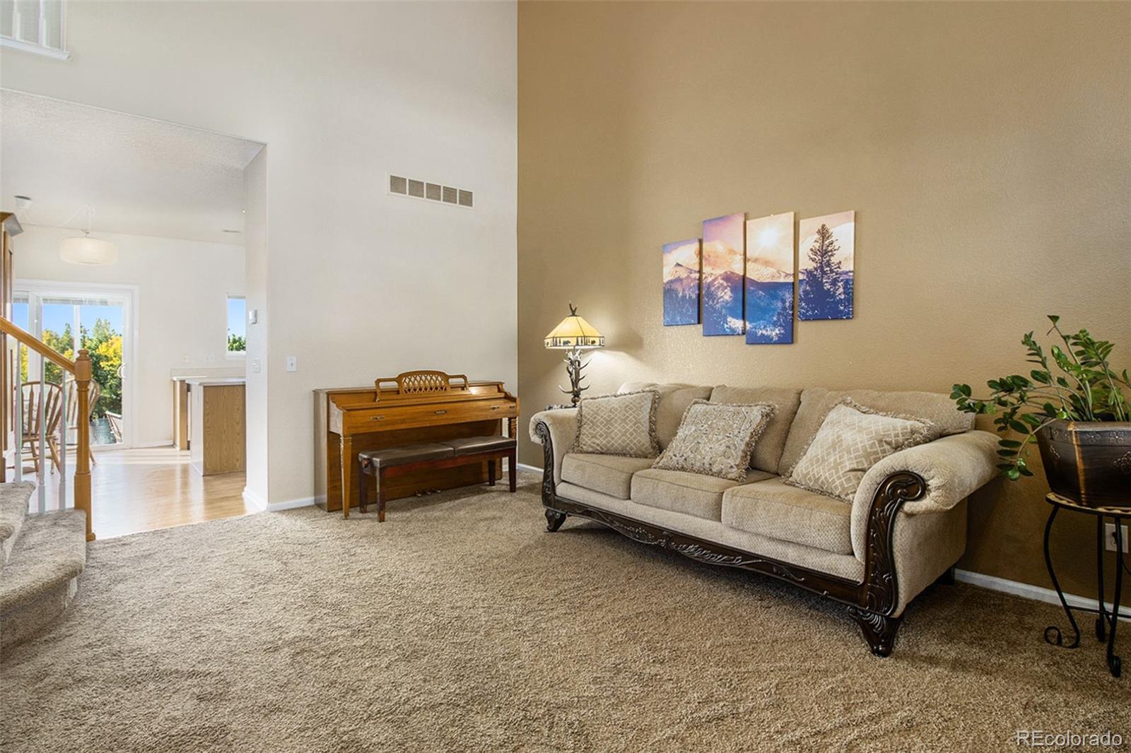 1082 Riddlewood Road Highlands Ranch, CO 80129 - Photo 4 of 28 a living room with a couch and a potted plant on coffee table