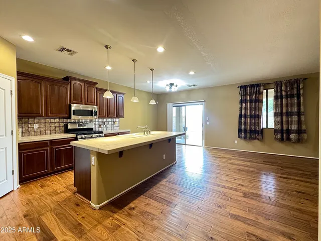 a large kitchen with stainless steel appliances a large island in the center