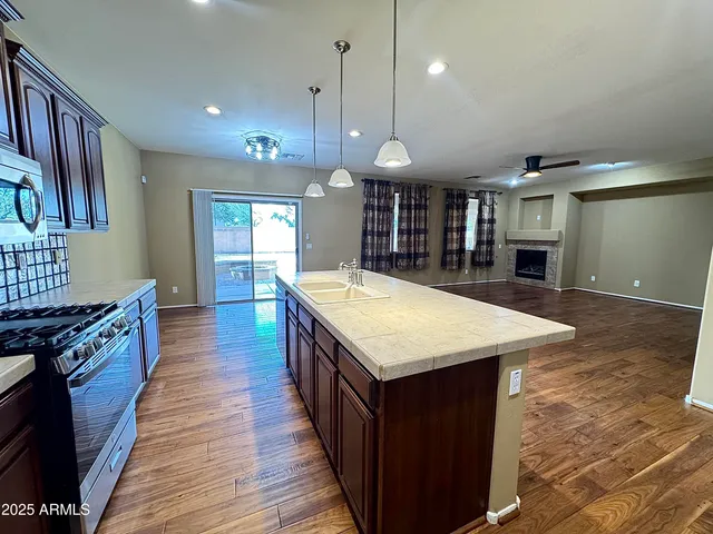 a view of a livingroom with a furniture wooden floor and a ceiling fan