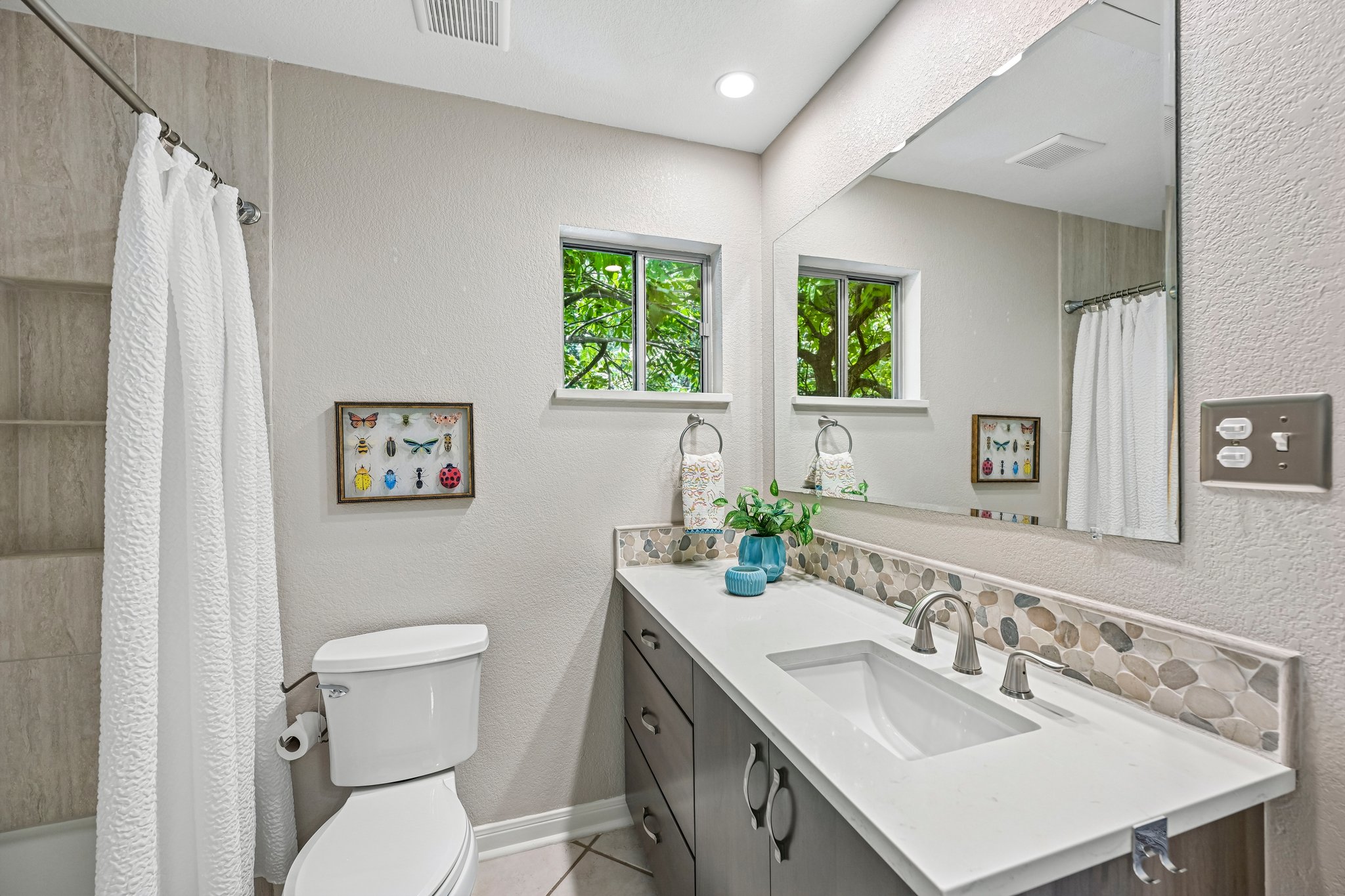 2412 Enfield Road, Unit 8 Austin, TX 78703 - Photo 6 of 34 Pebble tile brings a little creek-bed texture to the bath, which feels especially right when half the windows look into the trees.